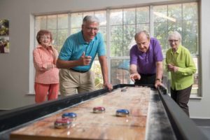 A group of senior adults plays shuffleboard
