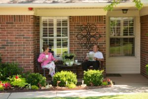 A couple sit on their front porch
