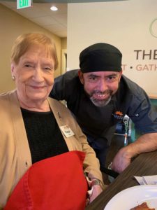 A senior adult poses with the chef in a restaurant at Epworth Villa