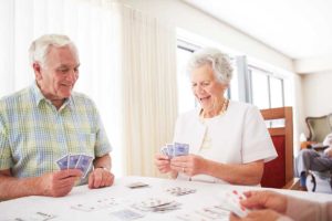 man and woman having fun playing cards