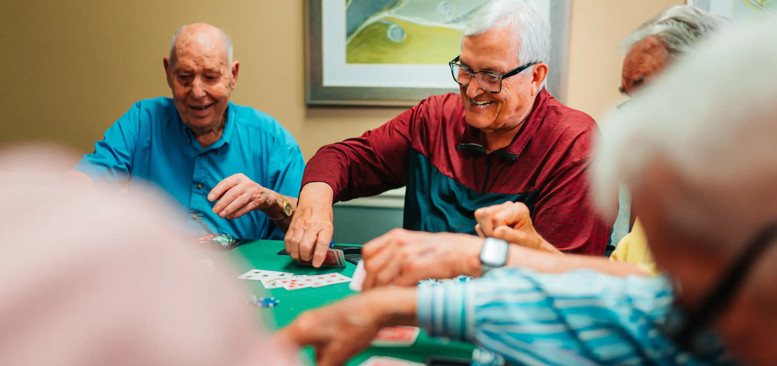 A group of senior adults set up a round of cards at a card table